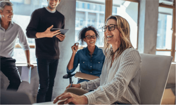 NovoCure team collaborating in a modern office with computers and digital screens